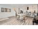 Bright dining area with a white table, wood chairs, a modern kitchen, and durable wood-look flooring at 1599 S Telluride St, Aurora, CO 80017