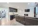 Basement living room featuring a kitchenette, sleek cabinets, and a comfortable brown leather couch at 1599 S Telluride St, Aurora, CO 80017