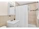 Bright bathroom featuring neutral tiles, a shower with a white curtain, and a vanity sink at 3198 W Amherst Ave, Denver, CO 80236