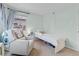 Cozy bedroom featuring a glider, a toddler bed with adorable plush toys, and soft natural light at 3198 W Amherst Ave, Denver, CO 80236