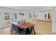 Open dining area connects to a modern kitchen with stainless steel appliances and bright lighting at 3198 W Amherst Ave, Denver, CO 80236