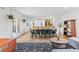 Open-concept dining area with modern table and chairs, flowing into the living room and kitchen at 3198 W Amherst Ave, Denver, CO 80236