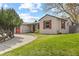 Charming single-story home with a red garage door, manicured lawn, and mature landscaping at 3198 W Amherst Ave, Denver, CO 80236