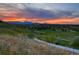 Scenic community sunset view showcases a lush landscape with a walking path and distant mountain views at 5388 Routt St # B, Arvada, CO 80002