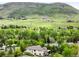Picturesque aerial view of a home nestled amidst lush greenery and rolling hills at 6032 Umber St, Arvada, CO 80403