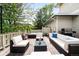 Outdoor deck area furnished with sofa, chairs, and hot tub overlooking wooded yard at 6032 Umber St, Arvada, CO 80403