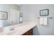 Bathroom features white single vanity, framed mirror, and coastal themed art at 6032 Umber St, Arvada, CO 80403