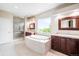 This spacious bathroom features a soaking tub, large window and double vanities at 6032 Umber St, Arvada, CO 80403