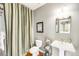 Bathroom featuring a pedestal sink, framed mirror, and decorative shower curtain at 6032 Umber St, Arvada, CO 80403