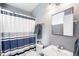 This bathroom features a shower with a privacy curtain, sink and toilet at 6032 Umber St, Arvada, CO 80403