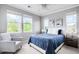 This bedroom features three windows, a ceiling fan and blue comforter at 6032 Umber St, Arvada, CO 80403
