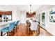 Bright dining area features hardwood floors, stylish lighting, and seamless connection to kitchen and outdoor spaces at 6032 Umber St, Arvada, CO 80403