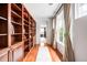 Hallway with hardwood floors, built-in bookshelves, and natural light from the windows at 6032 Umber St, Arvada, CO 80403