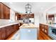 Spacious kitchen featuring a central island, stainless steel appliances, and ample dark wood cabinetry for storage at 6032 Umber St, Arvada, CO 80403