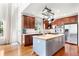 Well-appointed kitchen with an island, stainless steel appliances, and abundant dark wood cabinetry for storage at 6032 Umber St, Arvada, CO 80403