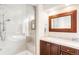 This bathroom features a glass enclosed shower, double vanity and framed mirror at 6032 Umber St, Arvada, CO 80403