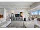 Bright living room with large TV, shelving, and balcony access with views of the surrounding landscape at 7877 E Mississippi Ave # 1008, Denver, CO 80247