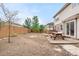 A spacious backyard with a wood fence, wooden picnic table, hot tub, and stone pathway at 13664 Linden Ct, Thornton, CO 80602