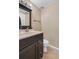 Cozy bathroom featuring a dark vanity, mirror, and a standard toilet at 13664 Linden Ct, Thornton, CO 80602