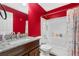 Bathroom with red accent wall, granite counter, and tub shower combo at 13664 Linden Ct, Thornton, CO 80602