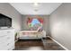 A quaint bedroom featuring dark wood floors, a white metal bed, and a soft-toned gray wall at 13664 Linden Ct, Thornton, CO 80602