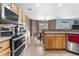 Well-lit kitchen with stainless steel appliances, including oven and microwave, as well as wooden cabinetry at 13664 Linden Ct, Thornton, CO 80602