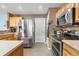 Spacious kitchen featuring stainless steel appliances, light wood cabinets, and tiled floors at 13664 Linden Ct, Thornton, CO 80602