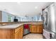 Open kitchen with stainless steel appliances, natural wood cabinets, and bright window at 13664 Linden Ct, Thornton, CO 80602