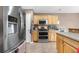 Spacious kitchen with stainless steel appliances, wooden cabinetry, and tiled floor with island at 13664 Linden Ct, Thornton, CO 80602