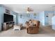A cozy living room with a ceiling fan, carpeted floors, blue walls, and comfortable brown seating at 13664 Linden Ct, Thornton, CO 80602
