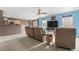 A cozy living room with blue accent walls, carpeted floors, and comfortable brown furniture at 13664 Linden Ct, Thornton, CO 80602