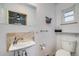 Bathroom with a small vanity, window and toilet with decorative shelving at 3200 Eastman Ave, Boulder, CO 80305