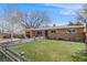 Traditional single-story brick home featuring a well-maintained front yard with a charming wooden fence at 3200 Eastman Ave, Boulder, CO 80305