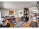 Open-concept living room with a wood burning stove, hardwood floors, and seamless flow into the dining area at 3200 Eastman Ave, Boulder, CO 80305