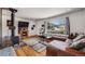 Bright living room featuring a wood-burning stove, hardwood floors, and a large window with neighborhood views at 3200 Eastman Ave, Boulder, CO 80305