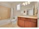 Bright bathroom with a shower-tub combo, shuttered window, and a wood vanity at 3751 W 136Th Ave # F4, Broomfield, CO 80023