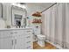 Bright bathroom with modern vanity, decorative shelves, and classic toilet design at 7946 S Kittredge St, Englewood, CO 80112