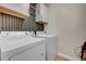 Practical laundry room featuring modern washer and dryer, with cabinet storage at 7946 S Kittredge St, Englewood, CO 80112