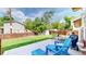 Back patio with blue Adirondack chairs surrounded by a well-manicured lawn and privacy fence at 6631 Welch Ct, Arvada, CO 80004