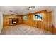 Finished basement with wood paneling, brick fireplace, carpeted floors and natural light from windows at 6631 Welch Ct, Arvada, CO 80004