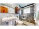 Modern bathroom with tiled shower, vanity with storage, and contemporary fixtures at 6631 Welch Ct, Arvada, CO 80004