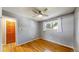 This bedroom offers hardwood floors, gray walls, a ceiling fan, and a window with white curtains at 6631 Welch Ct, Arvada, CO 80004