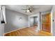 Neutral bedroom featuring hardwood floors, mirrored closet doors, a ceiling fan, and an accent wall decoration at 6631 Welch Ct, Arvada, CO 80004