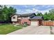 Inviting exterior elevation features a brick facade, attached garage, mature trees, and a well-kept lawn at 6631 Welch Ct, Arvada, CO 80004
