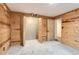 Basement room featuring wood walls, neutral carpet, and closet with bifold doors at 11155 Kennedy Ave, Conifer, CO 80433