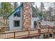 A-frame house with a stone chimney and wooden deck showcasing mountain views at 11155 Kennedy Ave, Conifer, CO 80433