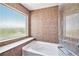 Luxurious soaking tub with a view is surrounded by custom tile work and a glass shower at 20108 Randolph Pl, Denver, CO 80249