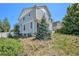 Light blue house with a lush green yard and mature trees at 20108 Randolph Pl, Denver, CO 80249