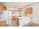 Well-lit kitchen featuring wood cabinetry, stainless steel appliances, and a breakfast bar overlooking the living area at 20108 Randolph Pl, Denver, CO 80249
