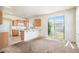 Open-concept kitchen with wood cabinets, a breakfast bar, and sliding glass doors to the backyard at 20108 Randolph Pl, Denver, CO 80249